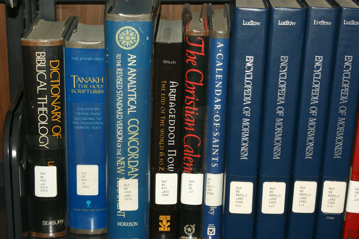 Various religious studies books on a shelf.